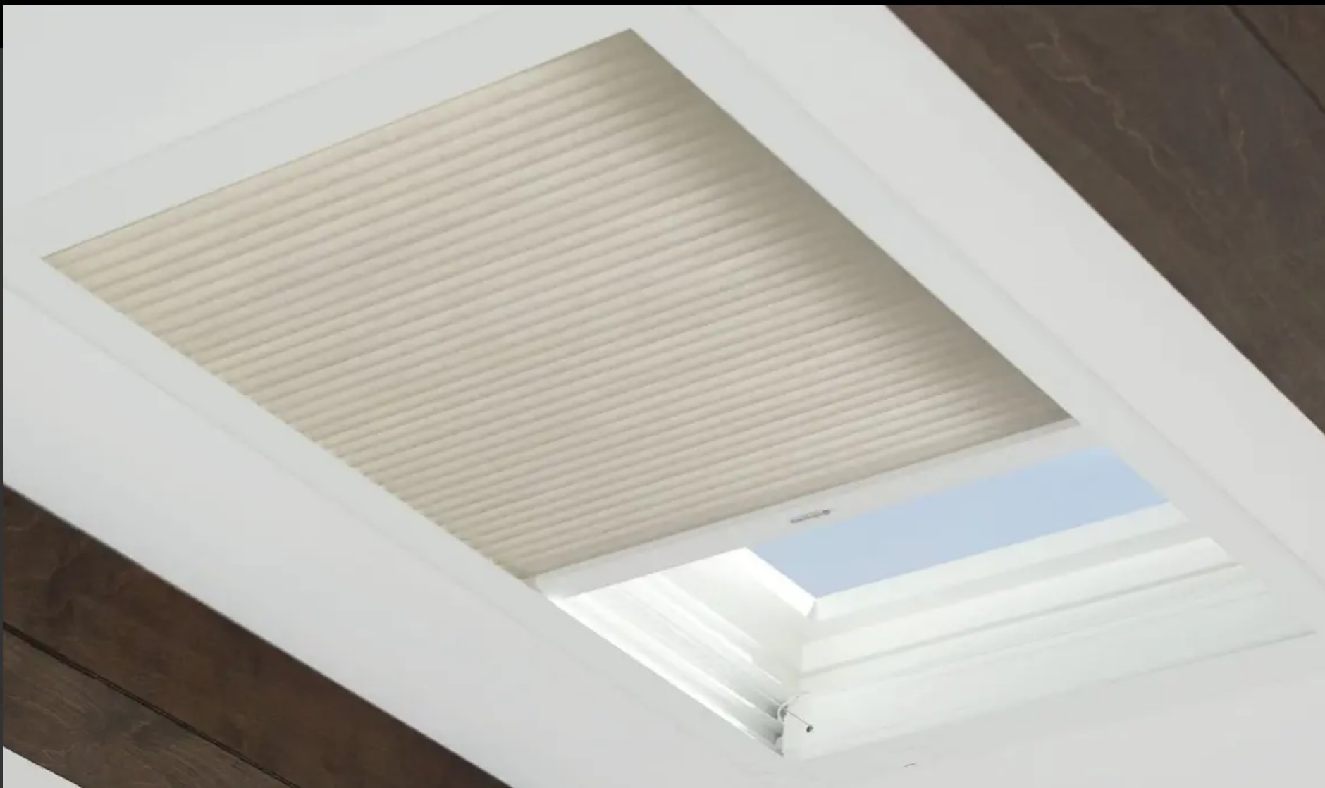 Cellular shade partially open on a skylight